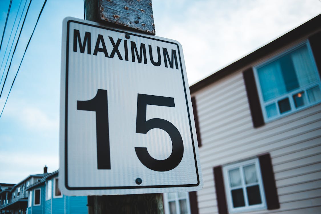 Free Regulatory road sign with Maximum inscription and number 15 against house facade in city in daytime Stock Photo