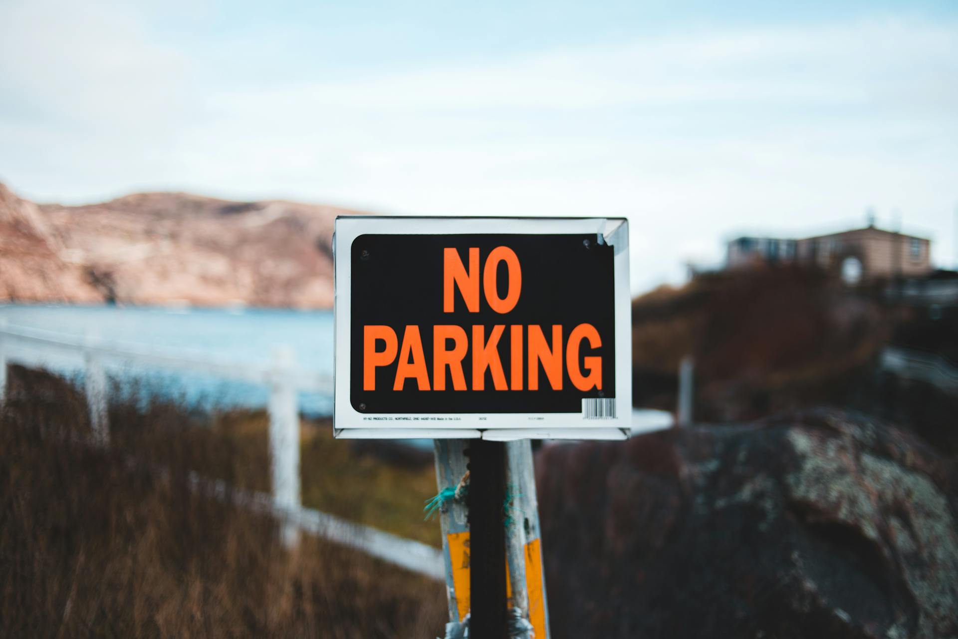 Signboard No parking placed in nature against blue lake