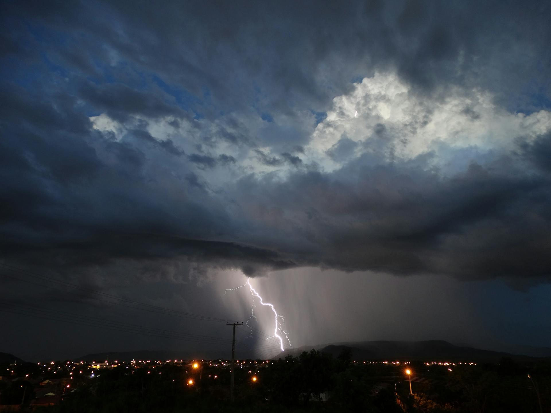 Captivating night scene of a thunderstorm with lightning over a cityscape, highlighting dramatic skies.