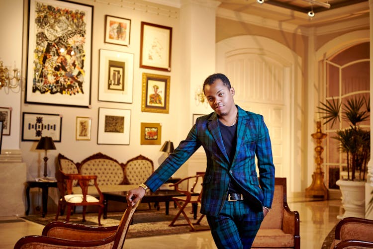 Man In A Blue Checkered Suit Standing In A Living Room