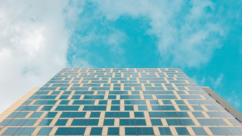 Free Upward view of a modern glass facade against a bright blue sky in Mexico City. Stock Photo