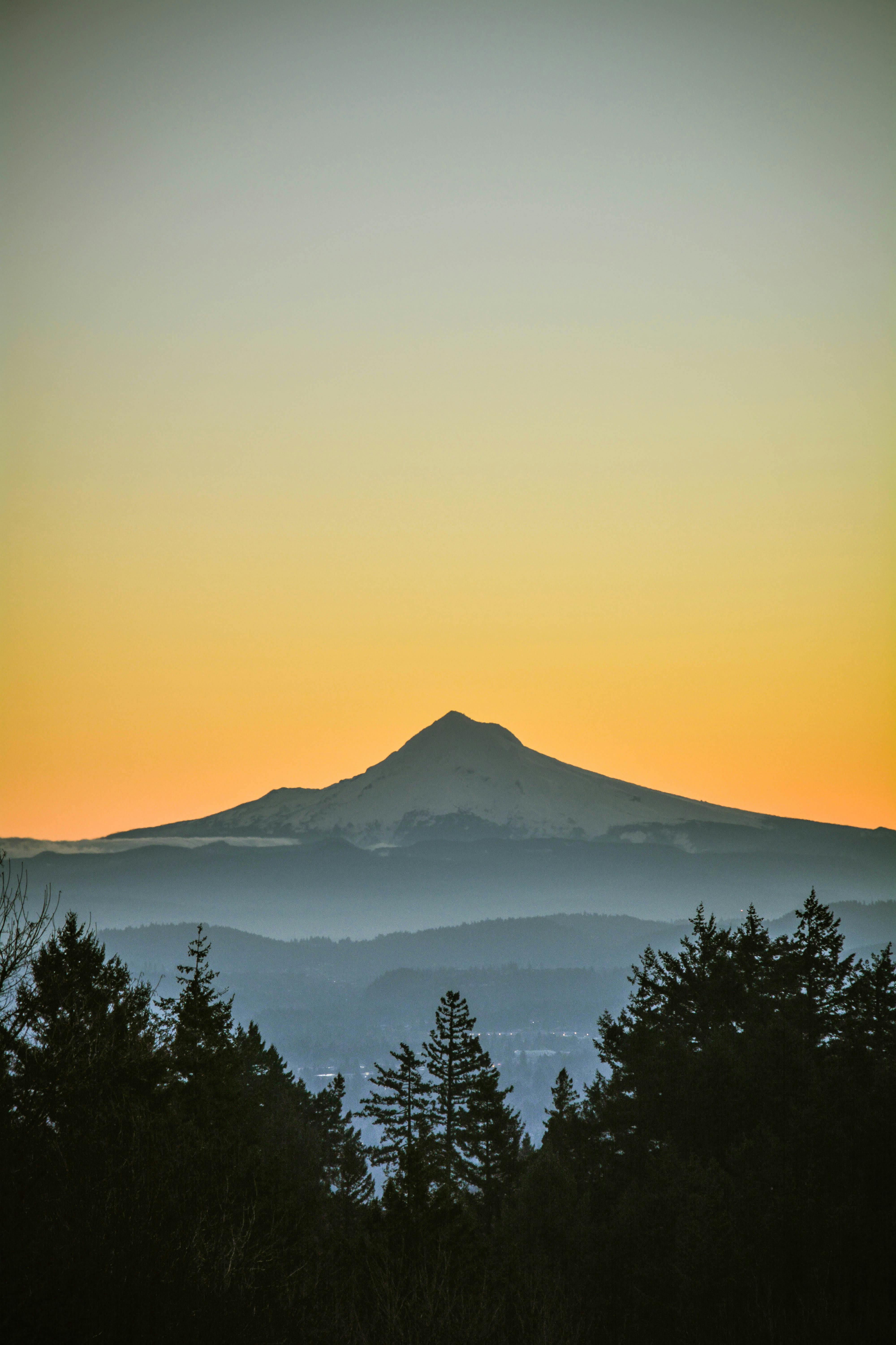 Beautiful sunset with Mount Hood silhouette against orange sky, viewed from Portland.