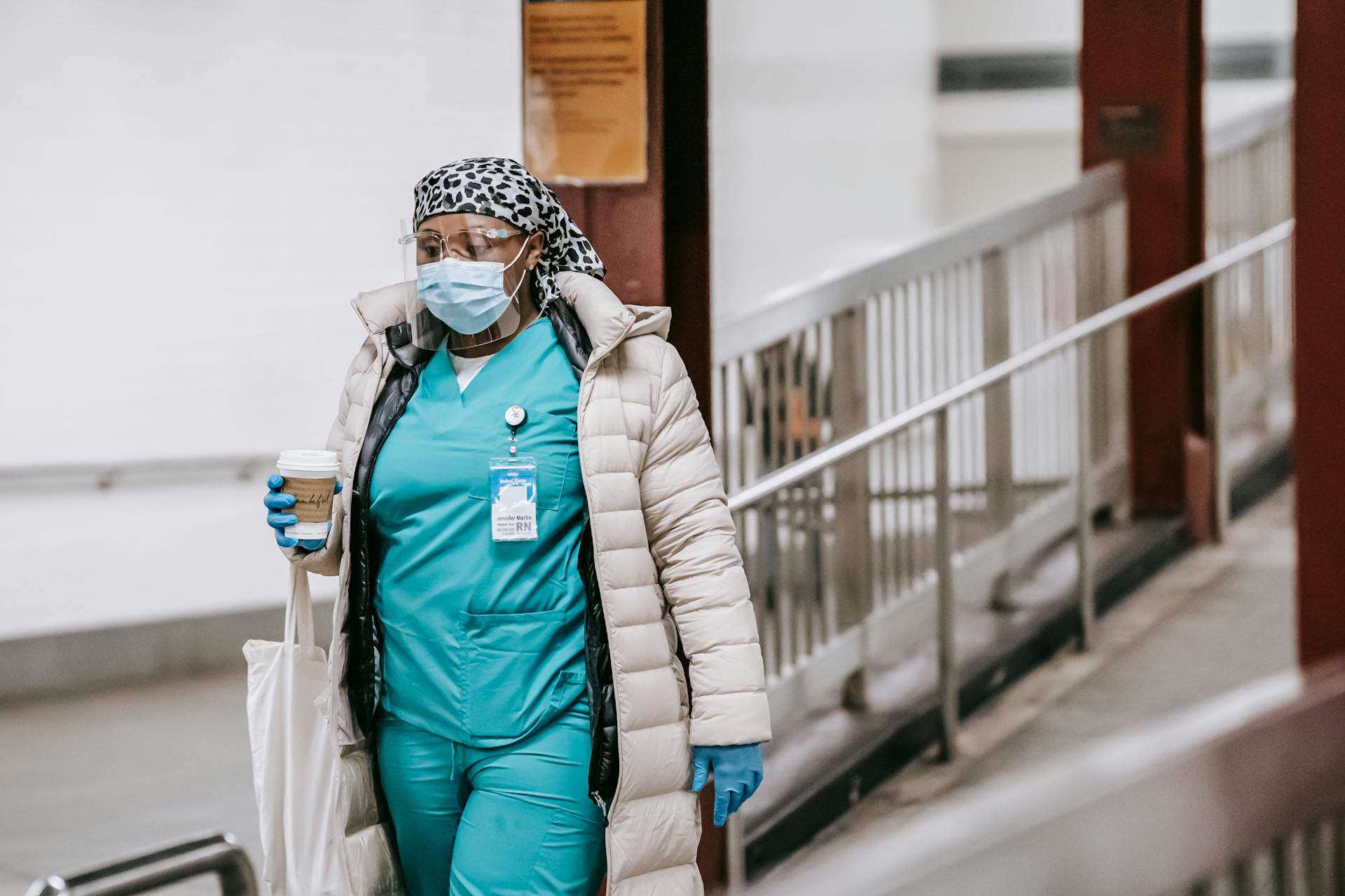 Black female nurse in uniform and protective mask on street