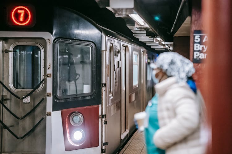 Nurse With Paper Cup On Subway Platform