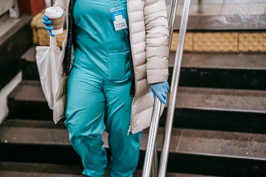Crop unrecognizable nurse going downstairs in pedestrian passage