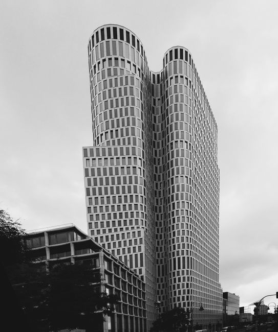 Black and white image of a contemporary skyscraper with a unique curved facade.