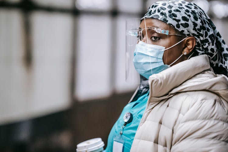 Thoughtful Black Nurse In Face Mask Standing On Metro Platform