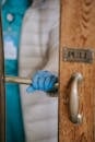 Faceless physician touching door handle in building