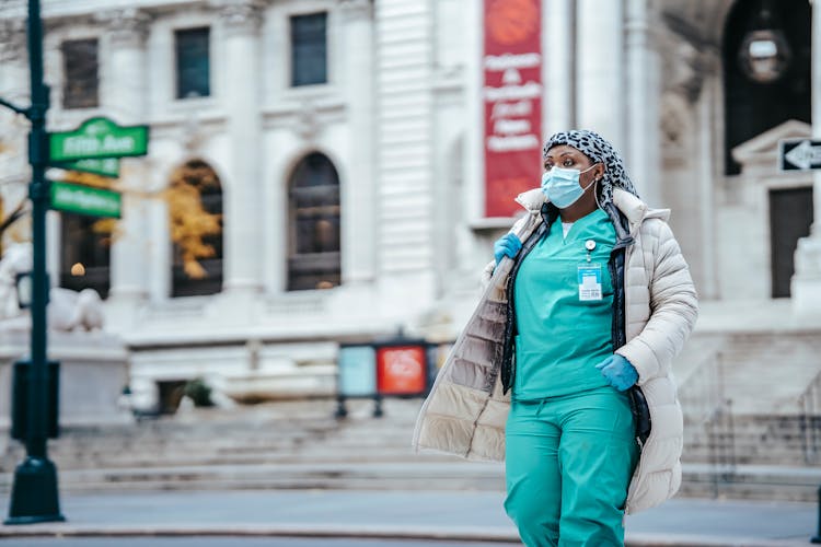 Ethnic Physician In Sterile Mask Walking On City Road