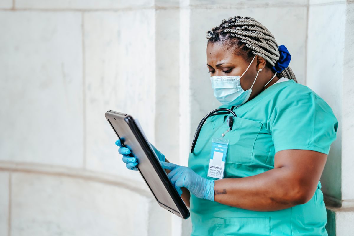 Healthcare professional reviewing information on a clipboard