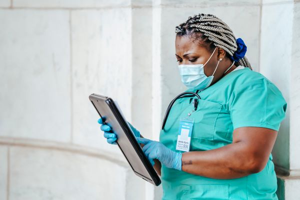 African nurse reviewing patient documentation, representing German for Healthcare