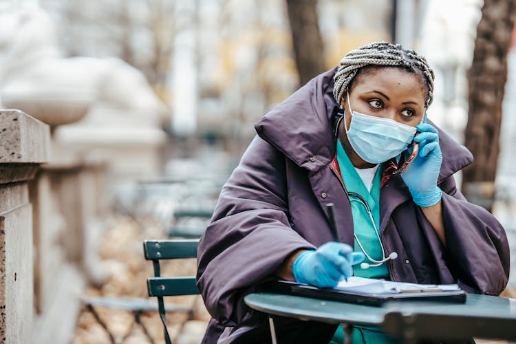 Ethnic Physician Speaking On Smartphone During Work In Park