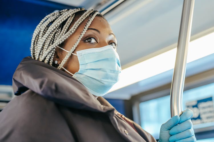 African American Female Standing In Bus In Pandemic