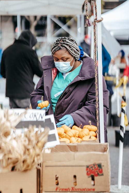 Free Black woman doctor picking food in market Stock Photo