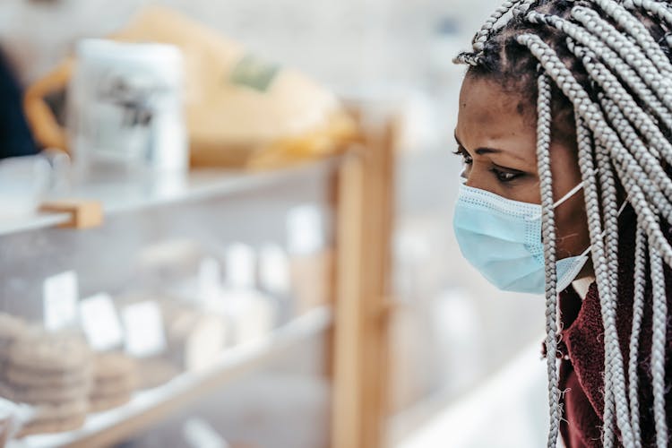 African American Woman In Mask Selecting Bakery Products From Showcase