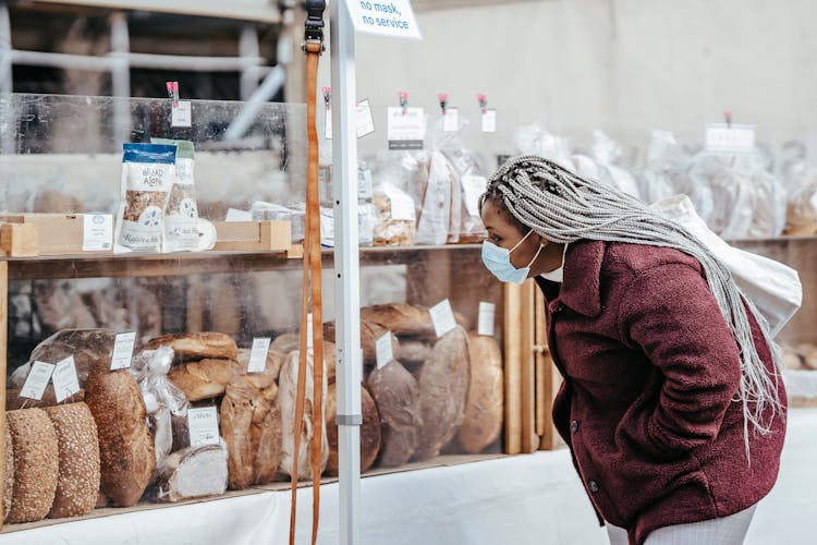 African American Female In Mask Picking Bakery Products In Market