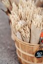 Bouquets with dried wheat with price placed in wooden bucket in daytime on road