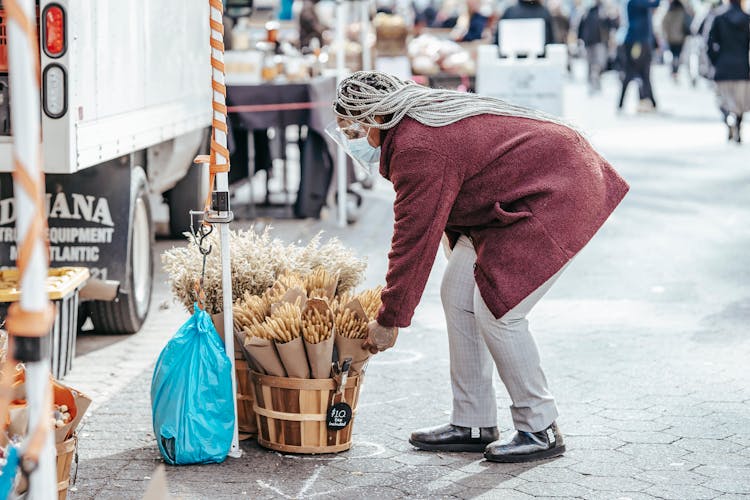 Black Female Selecting Bouquet Of Dried Wheat In Street