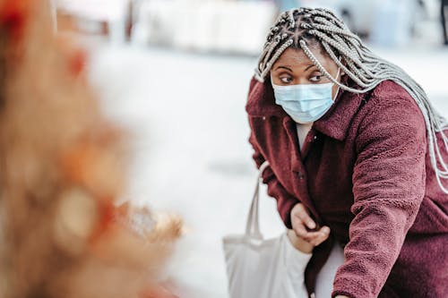 Black woman choosing goods on street market