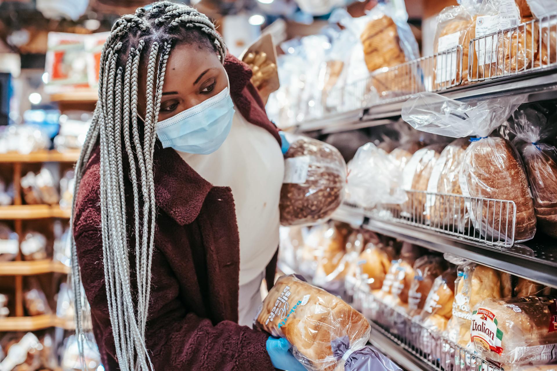 Black woman choosing bread in baking department