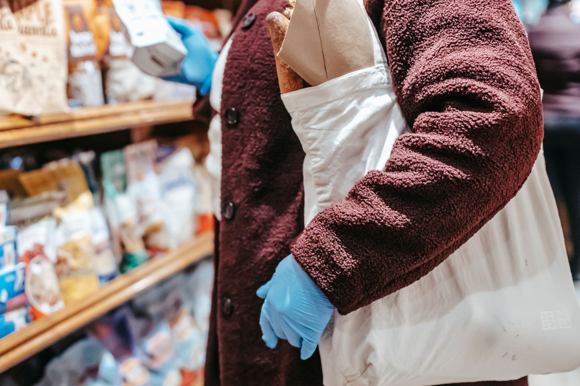 Woman with shopping bag choosing food in supermarket