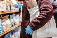 Woman with shopping bag choosing food in supermarket