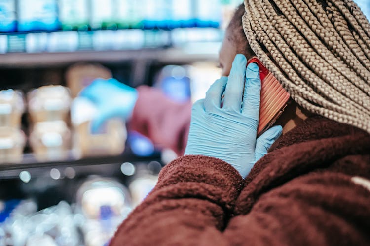 Black Woman Talking On Smartphone While Shopping In Store