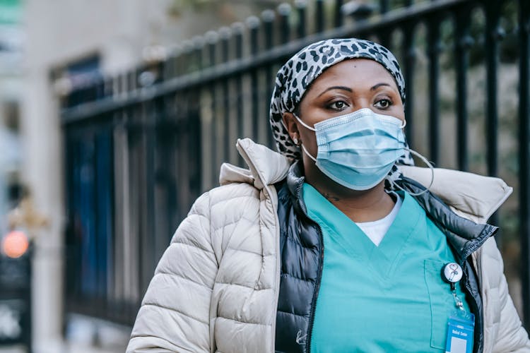 Calm Black Nurse In Face Mask Walking On Street