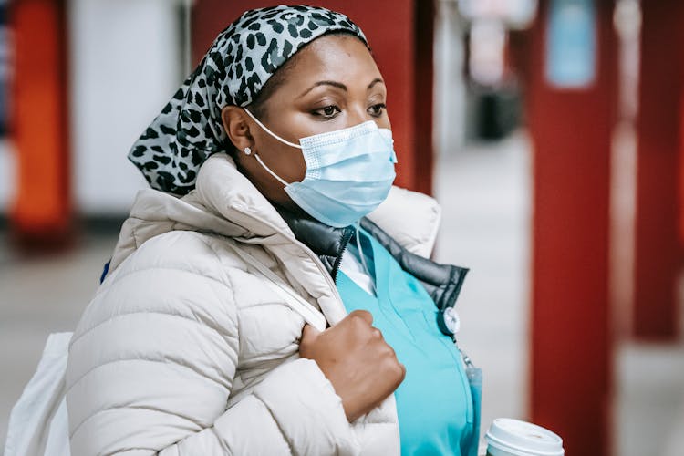 Pensive Black Nurse In Mask Standing In Public Place