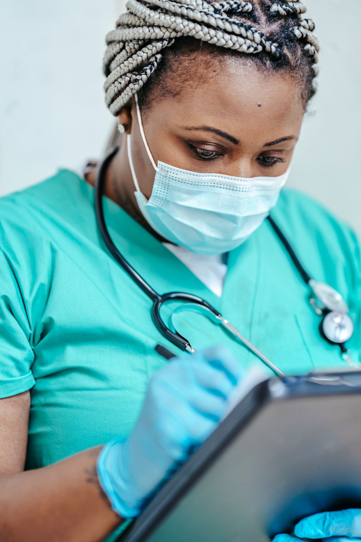 Nurse reviewing documents on a clipboard before an application