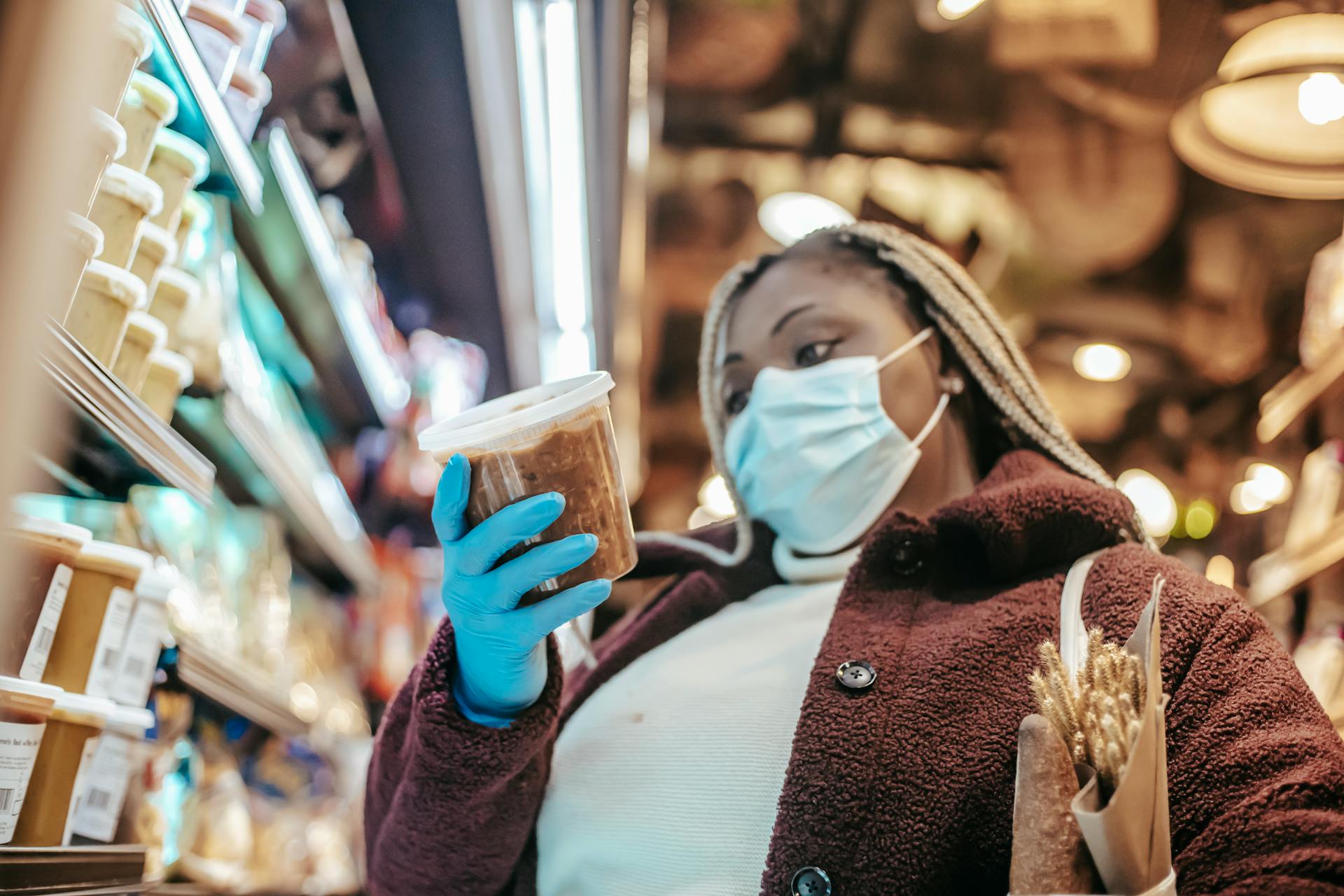 Black woman in protective mask buying products