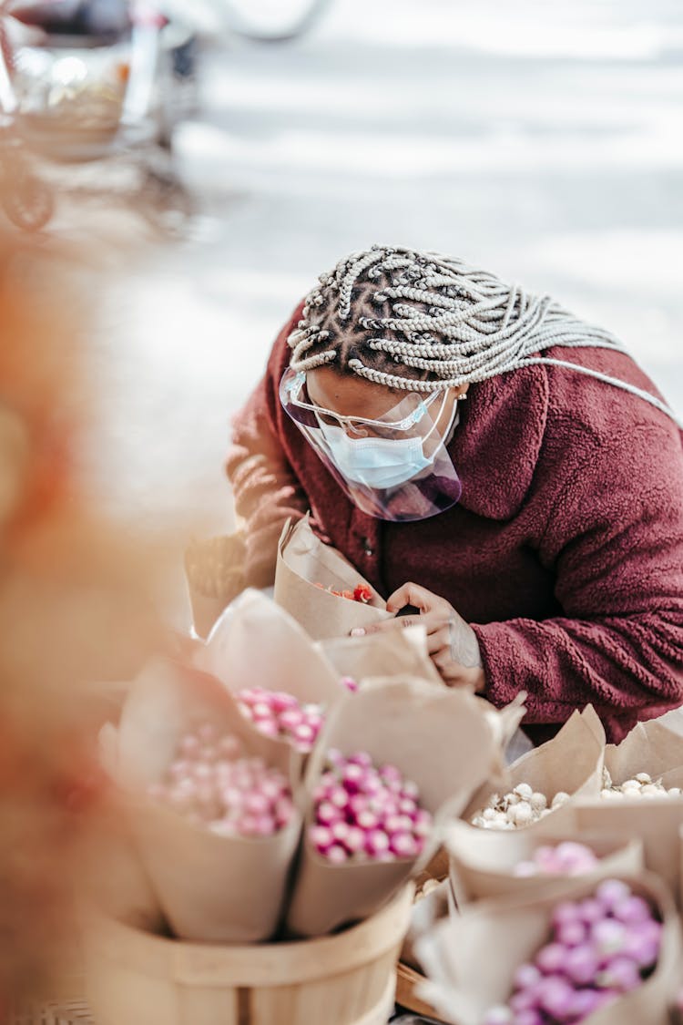 Ethnic Woman In Mask Standing On Street Near Floristry Store