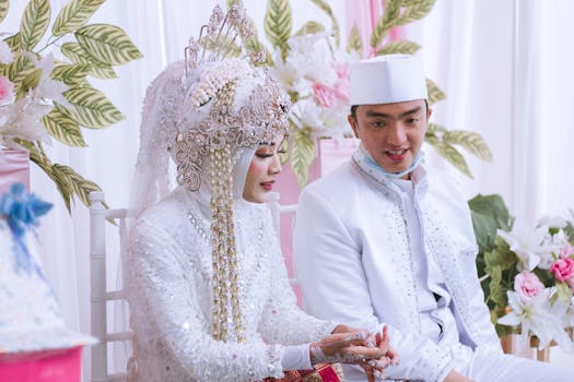 Beautiful couple in traditional attire during their wedding ceremony, surrounded by floral decorations.