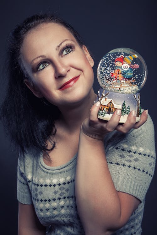 A Woman Holding a Snow Globe