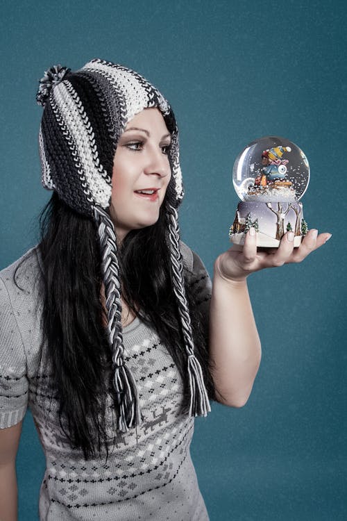 A Woman in Gray Shirt Holding a Snow Globe