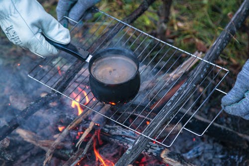 Person Making Coffee Over a Campfire