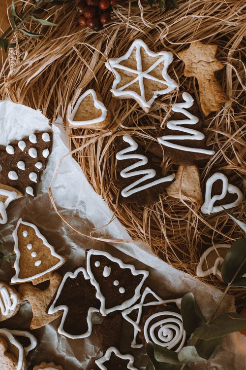Free An assortment of decorated gingerbread cookies in a rustic setting, perfect for a cozy Christmas atmosphere. Stock Photo