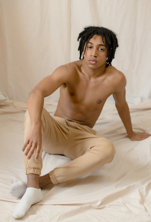 Topless Man Wearing Brown Pants Sitting 