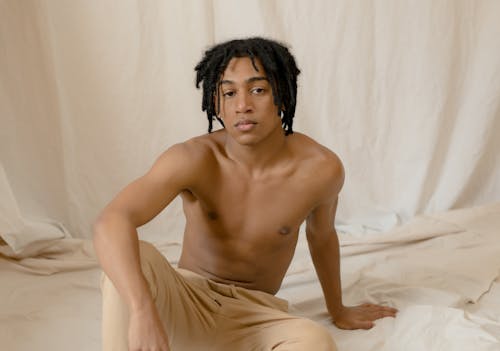 Topless Vrouw In Beige Rok Zittend Op Bed
