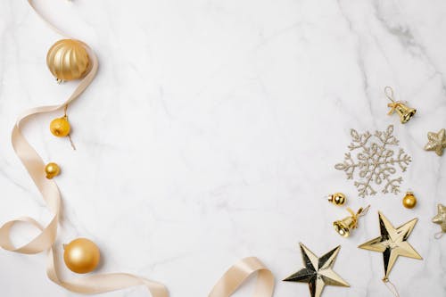 White and Gold Star and Ornaments on a Marble Surface