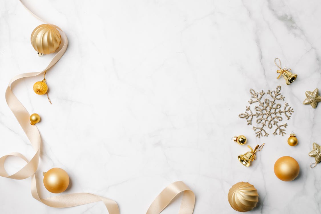 Shiny golden baubles and bells near snowflake and ribbon · Free Stock Photo