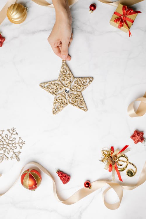 Person showing festive sparkling decorative star among Christmas decorations