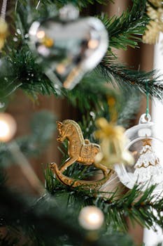 Close-up of decorative Christmas tree with ornaments including a rocking horse and heart.