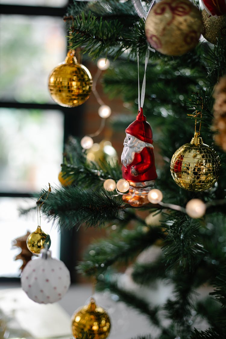 Decorated Christmas Tree With Baubles And Santa Claus Statuette