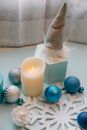From above of assorted baubles and burning candle on decorative snowflake during New Year holiday in house