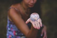 A woman holds a crystal ball in her hand, symbolizing mystery and future visions.