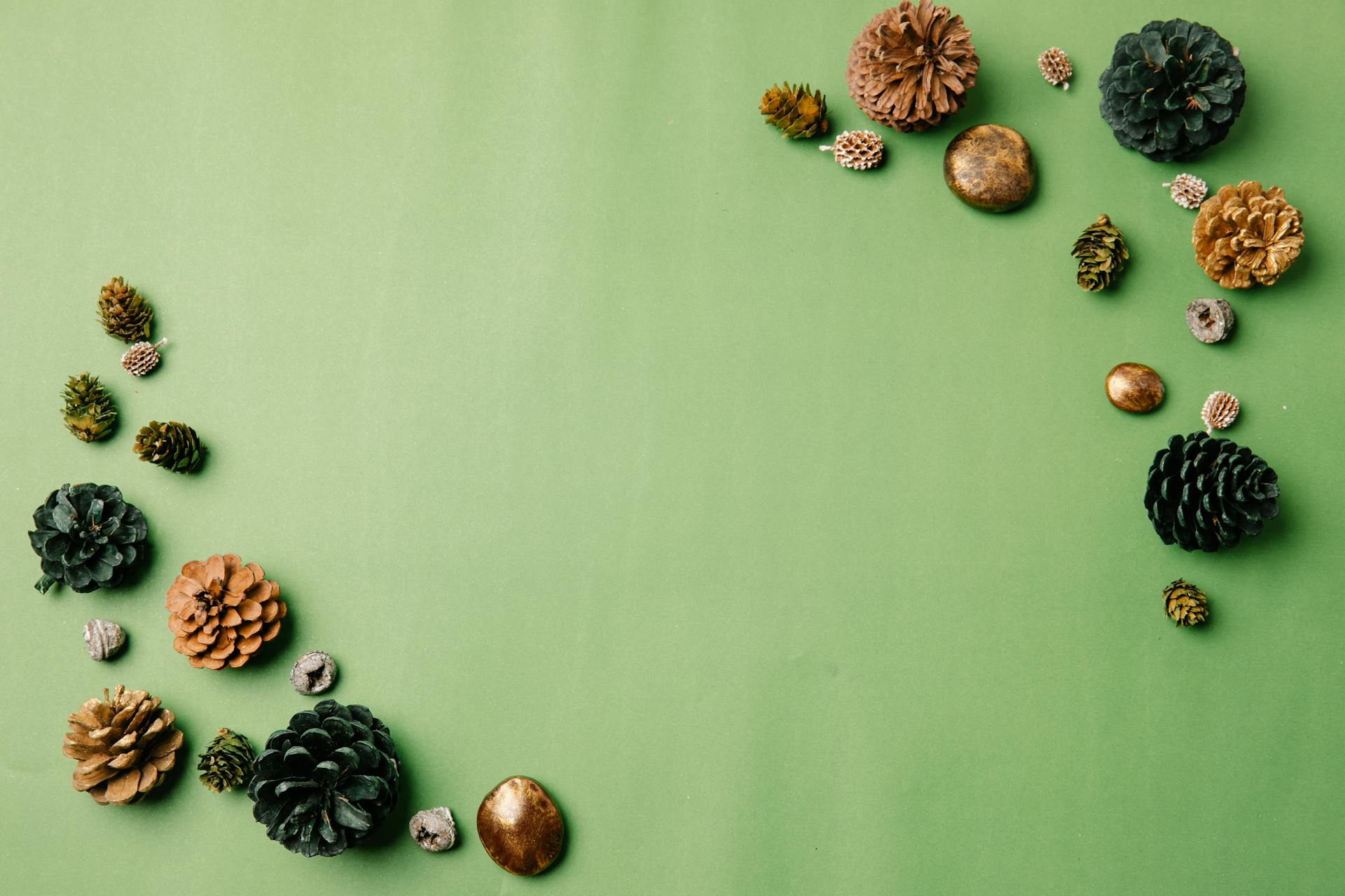 Artistic arrangement of pine cones and gold accents on a green background for seasonal decor.