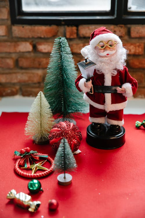 Estatueta De Papai Noel Ao Lado De Um Pinheiro Verde