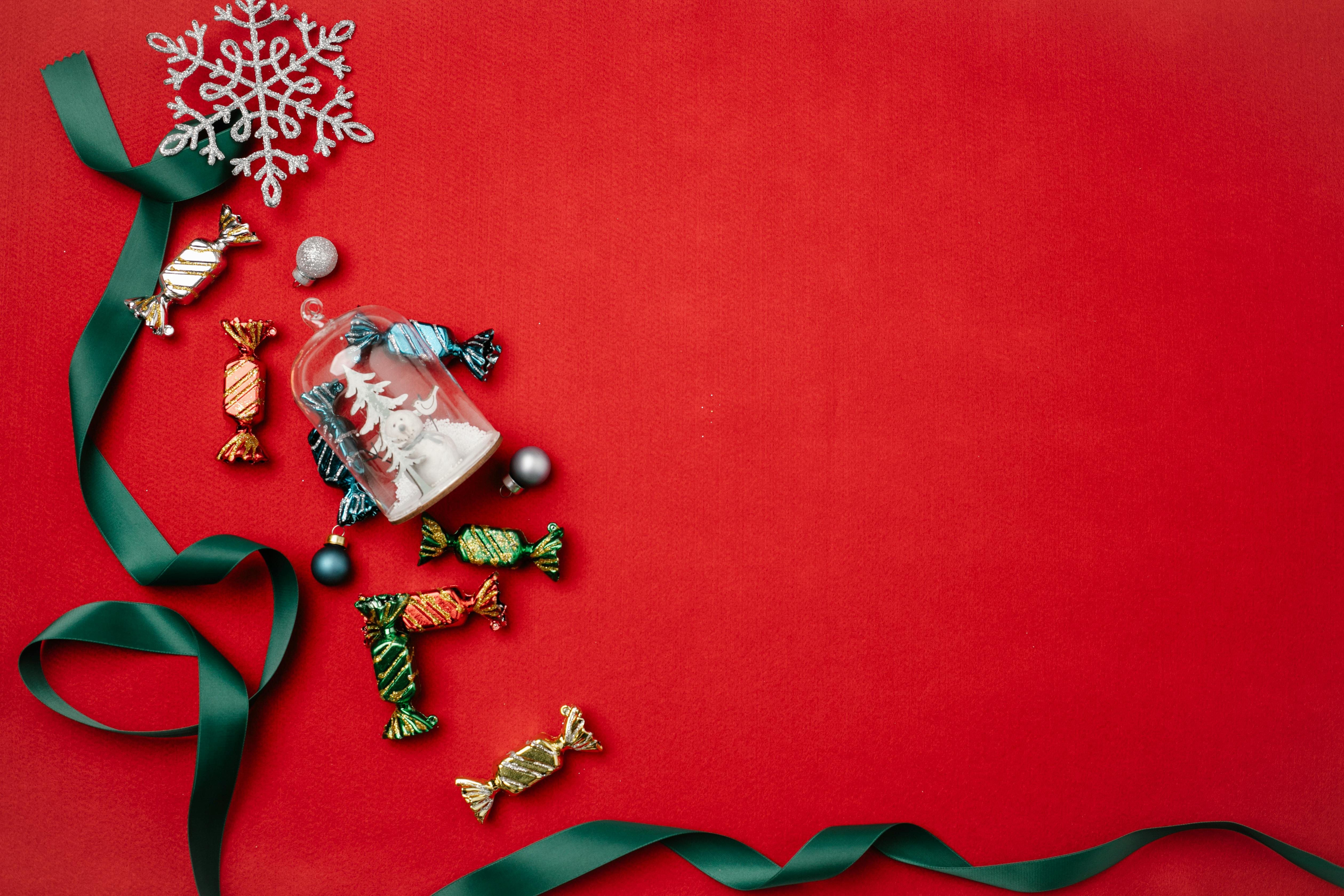 christmas decorations with ribbon on red surface