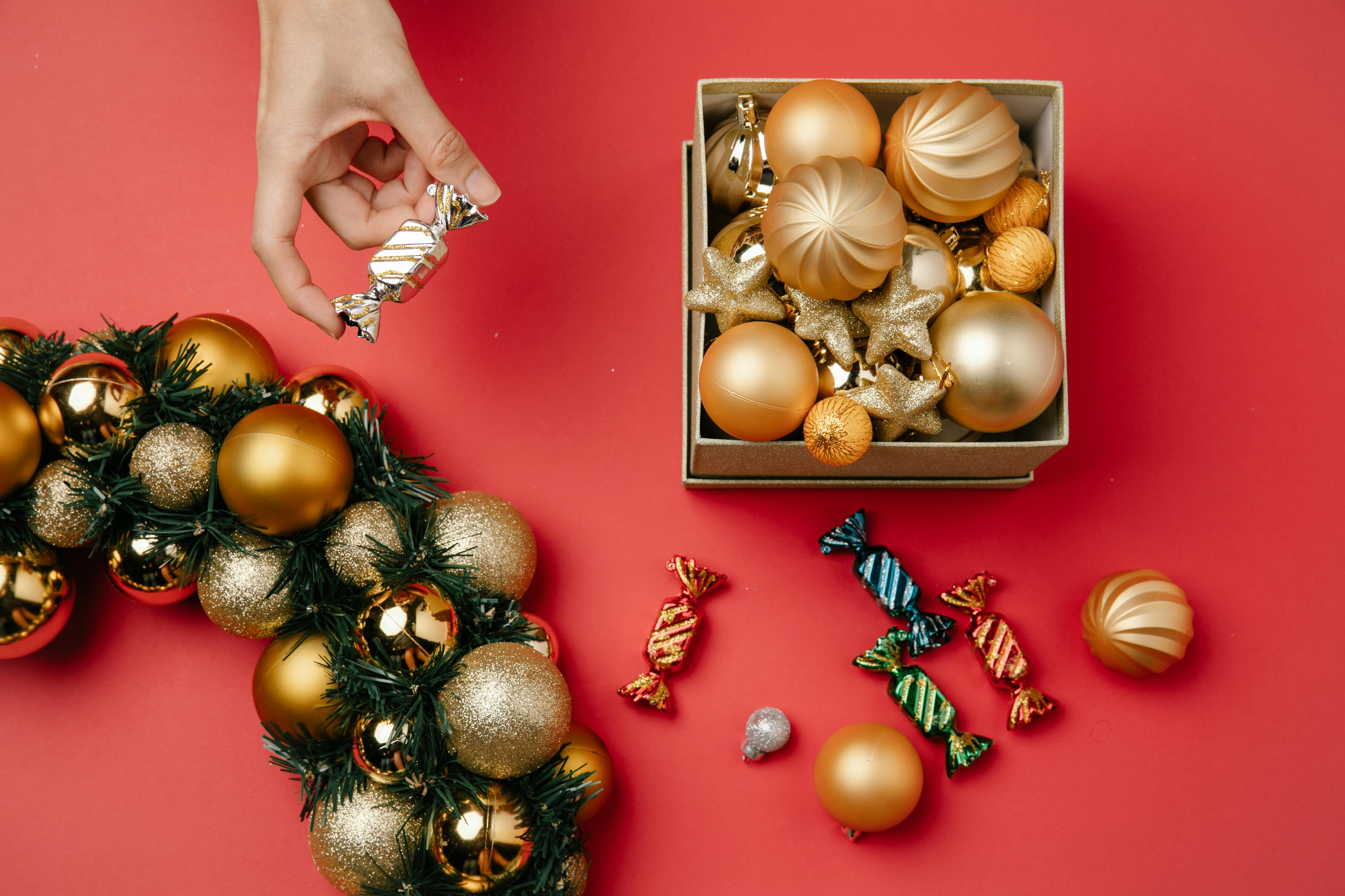 person taking bonbon from christmas composition